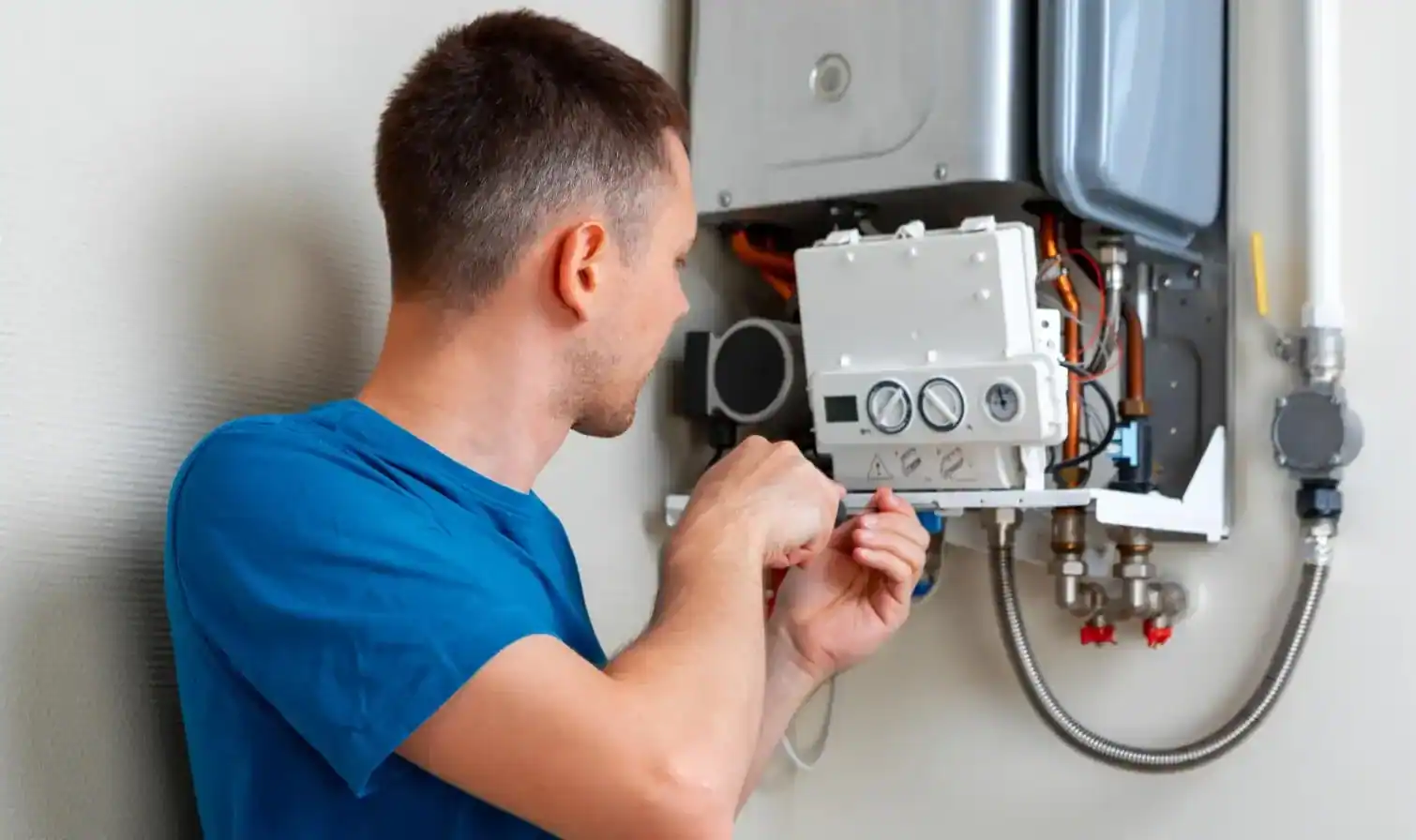 Installateur arbeitet an der Elektronik einer geöffneten Gastherme